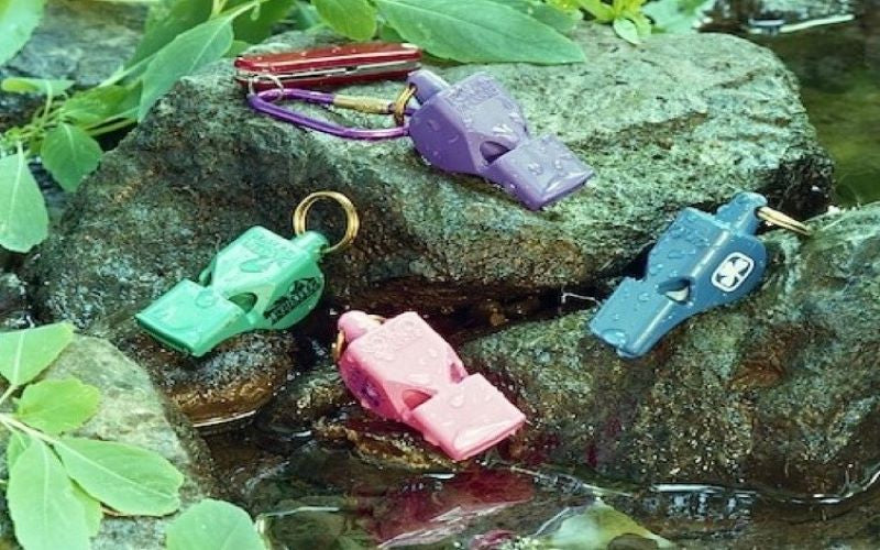 Water soaked pea-less 'Classic' & 'Mini' whistles in outdoors creek side setting. Wet or Dry - waterproof.