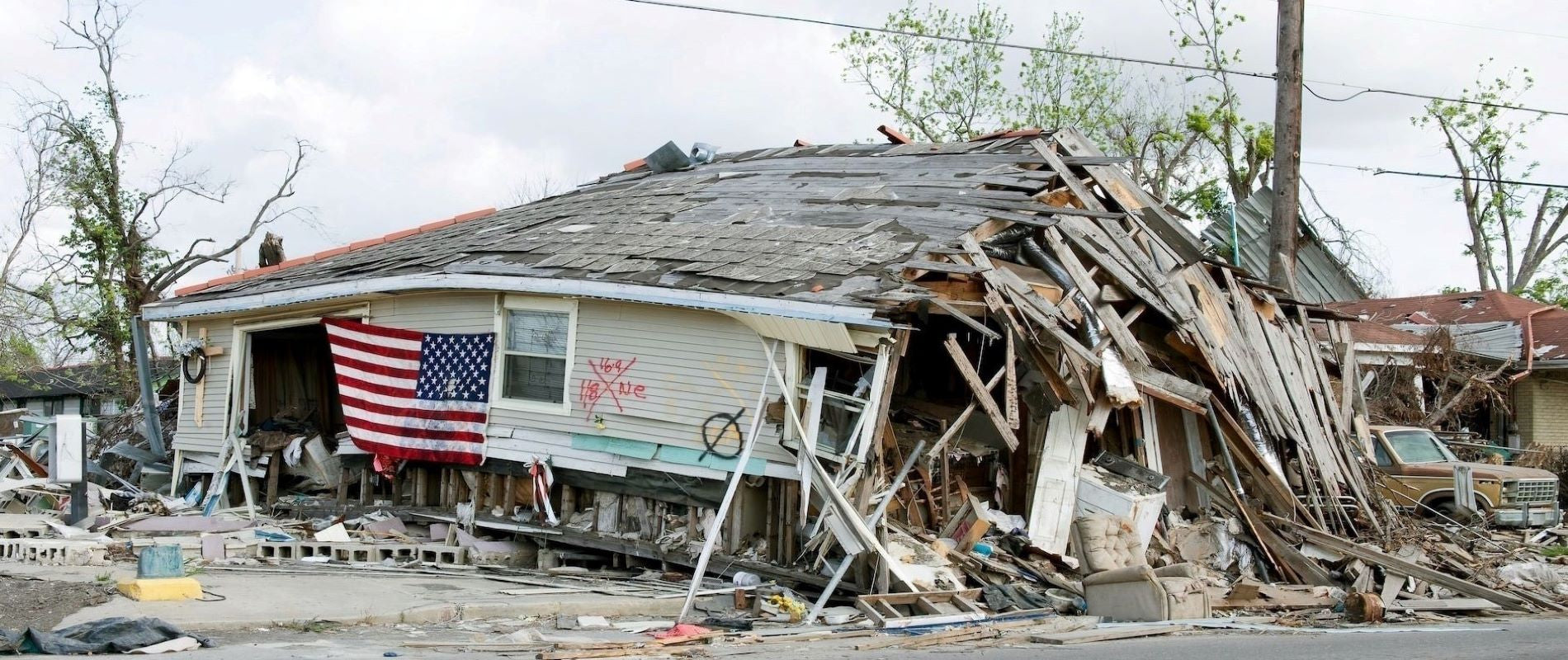Katrina - Hurricane force winds devasated home beyond repair. American Flag hung on outside of delapotated remains in advance of demolition.